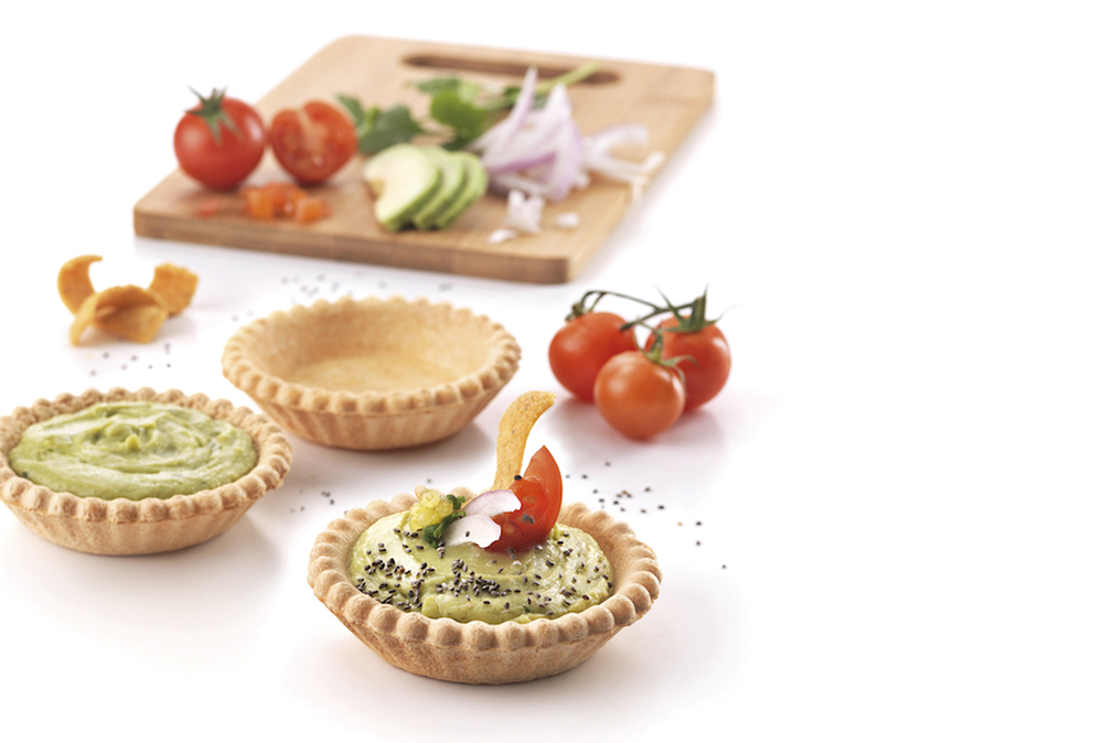 Organic tartlets filled with guacamole, nachos and chia